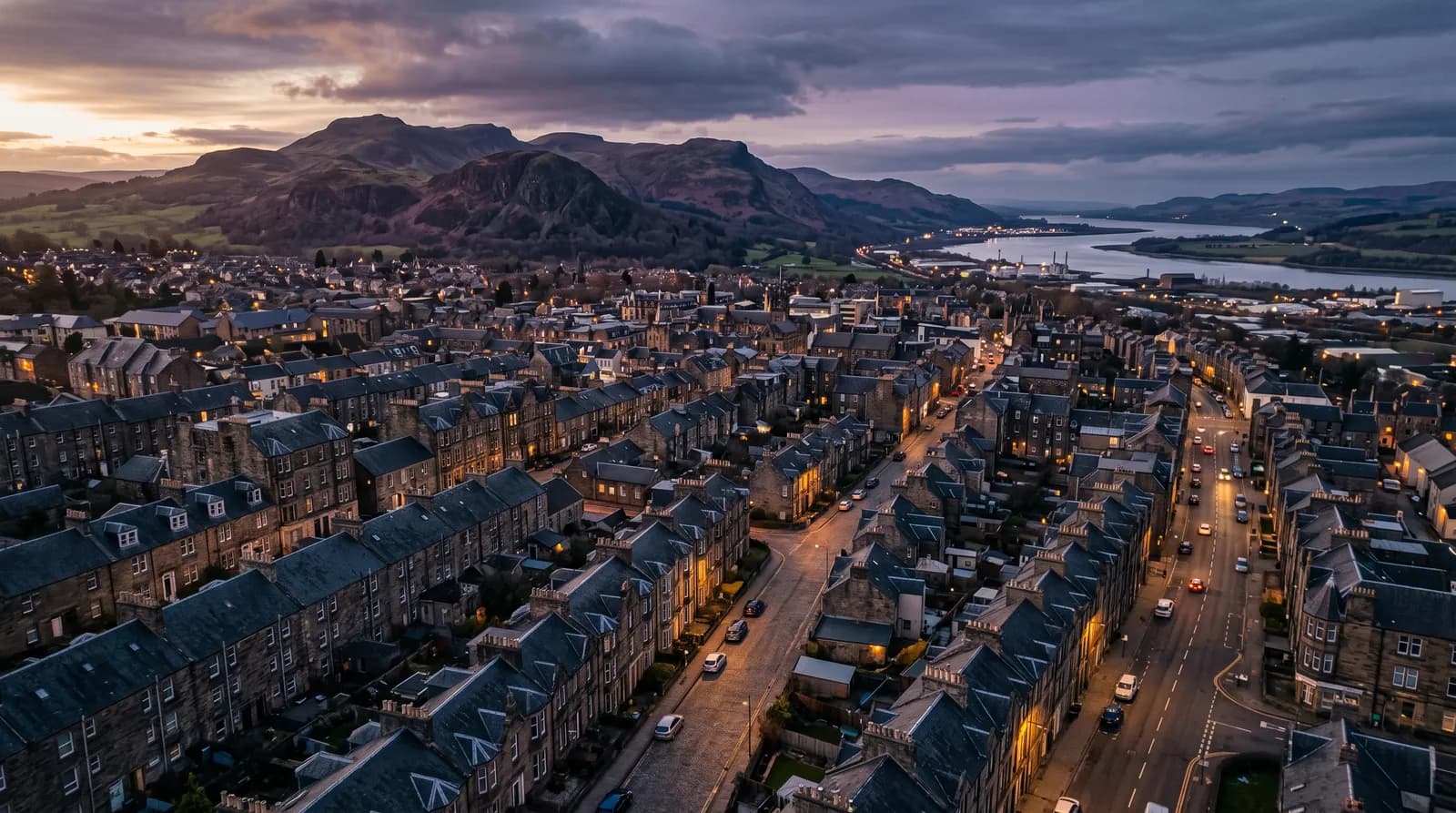 Central Scotland town rooftops at golden hour with the Ochil Hills and River Forth beyond